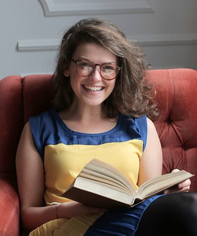 woman-in-blue-and-yellow-dress-sitting-on-red-sofa